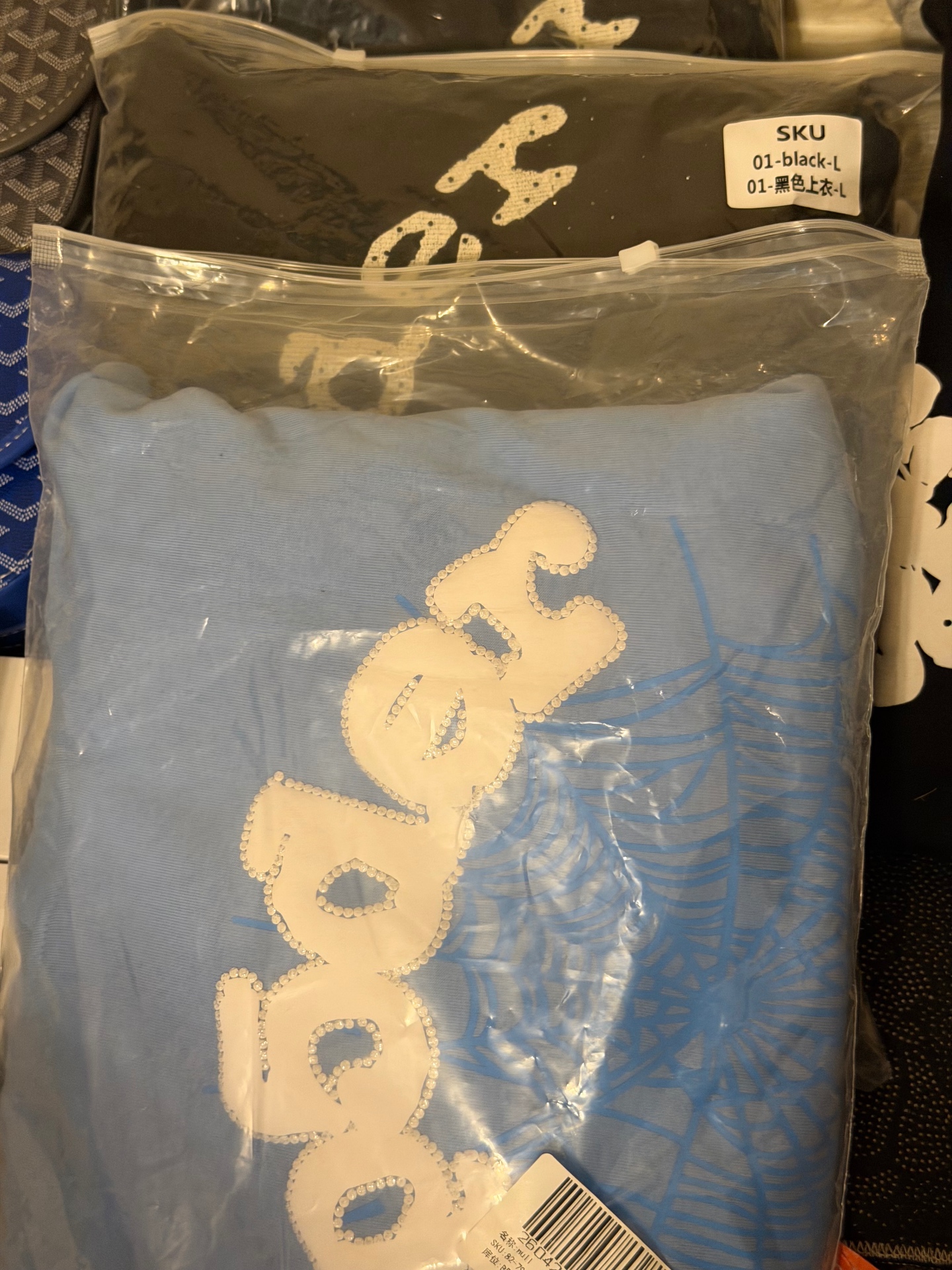 Sealed rhinestone graphic tees with SKU labels from the apparel vendor vault